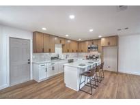 Bright kitchen features stainless steel appliances, an island with seating, and white countertops at 5279 Consul Ave, Las Vegas, NV 89142