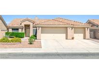 Charming home with a three-car garage and well-maintained front yard at 5704 Owl Butte Ct, Las Vegas, NV 89149