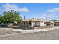 Single story home featuring a chain link fence and a well-manicured lawn at 600 Federal St, Henderson, NV 89015