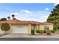 Inviting single-story home featuring a red tile roof, lush landscaping, and an attached two-car garage at 7232 Vista Bonita Dr, Las Vegas, NV 89149