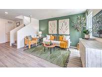 Inviting living room featuring green accent wall, neutral furniture, stylish decor, and luxury vinyl plank flooring at 7351 Kyle Cove Dr # Lot 208, North Las Vegas, NV 89084