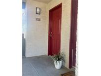 Condo front door with red finish, house number, and exterior light fixture at 8600 W Charleston Blvd # 2033, Las Vegas, NV 89117