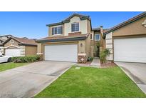 Charming two-story townhome with a two-car garage, stone accents, and a well-maintained lawn at 10311 Birch Bluff Lane Ln, Las Vegas, NV 89145