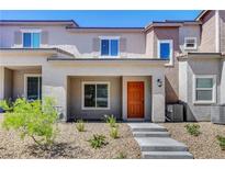 Inviting two-story home features an orange front door, low maintenance landscaping, and a concrete walkway at 10773 Bede Ct, Las Vegas, NV 89166