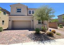 Charming two-story home showcasing neutral stucco, brick driveway, and a well-manicured front yard at 2125 Stone Well Rd, North Las Vegas, NV 89031