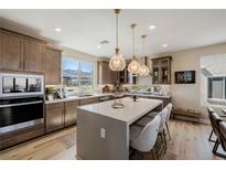 Bright kitchen boasts a large island, quartz countertops, pendant lights, and stainless steel appliances at 2151 Noble Perch St, Las Vegas, NV 89138