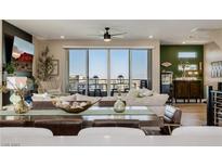 An open living room with modern furnishings and a sliding glass door to a balcony with a view at 2151 Noble Perch St, Las Vegas, NV 89138