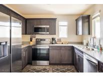 Modern kitchen featuring stainless steel appliances, dark cabinets, and granite countertops at 2629 Mocha Pearl Ct, North Las Vegas, NV 89086