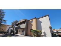 Two-story condo with stucco siding and wood stairs leading to the second level under a clear blue sky at 3151 Soaring Gulls Dr # 2058, Las Vegas, NV 89128