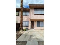 Two-story townhome featuring a stucco exterior, double-pane windows, and a mature palm tree in the front yard at 4363 Spencer St # 8, Las Vegas, NV 89119
