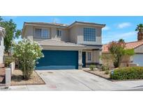 Two-story home features blue garage door, desert landscaping, and concrete driveway at 5204 Padua Way, Las Vegas, NV 89107
