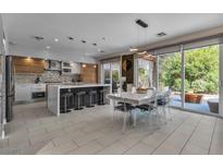 Bright, modern kitchen featuring an island with seating and stainless steel appliances, with easy access to outdoor patio at 556 Caribbean Palm Dr, Las Vegas, NV 89138