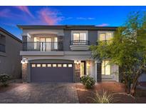 Charming two-story home boasts a stone facade, a two-car garage and a cozy second-story balcony at 6618 Tangled Vines Ave, Las Vegas, NV 89139