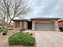 Inviting single-story home with a paver driveway, desert landscaping, and a charming, covered entry at 6946 Motley Rd, Las Vegas, NV 89178