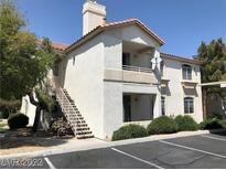 Condo exterior with a private balcony, stair access, and manicured landscaping at 75 N Valle Verde Dr # 2121, Henderson, NV 89074
