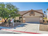 Inviting single-story home featuring a well-maintained lawn and a two-car garage at 7515 Splashing Rock Dr, Las Vegas, NV 89131