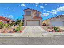 Two-story home showcasing a neutral stucco facade, red tile roof, well-kept landscaping, and an attached two-car garage at 1025 Clover Tip Ct, Las Vegas, NV 89123
