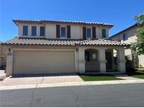 Two-story home with a two-car garage, covered porch, tile roof, and low-maintenance front yard at 1069 Coronado Peak Ave, Las Vegas, NV 89183