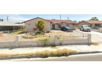 Charming single-story home with mature palm tree and white fence in a suburban neighborhood at 1301 Madison Ave, Las Vegas, NV 89106