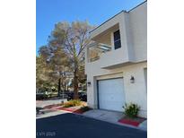 Two-story exterior with a two-car garage, balcony, desert landscaping, and neutral color scheme at 2761 Lodestone Dr # 63, Las Vegas, NV 89117