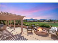 Spacious back patio featuring a pergola, outdoor kitchen, fire pit, and views of the golf course at 2917 Golf Links Dr, Las Vegas, NV 89134