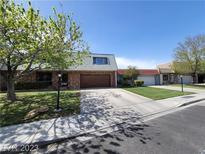 Charming single-story home with brick facade, mature trees, and a well-maintained front yard and driveway at 3797 Monument St, Las Vegas, NV 89121
