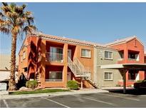 Condominium exterior featuring red and beige paint, multiple levels, stairs, and landscaping at 4730 E Craig Rd # 1148, Las Vegas, NV 89115