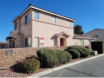 Tan two-story townhome featuring a tile roof, manicured shrubbery, and a no-parking sign at 70 Belle Essence Ave, Las Vegas, NV 89123