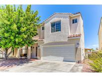 Two-story home with a two car garage, desert landscaping and a covered front porch with a porch swing at 7900 Dutch Canyon Ct, Las Vegas, NV 89131