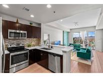 Modern kitchen and living room area with stainless steel appliances, light countertops, and views at 8255 Las Vegas Blvd # 1219, Las Vegas, NV 89123