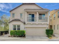 Two-story home with a tan stucco exterior, a balcony, and a two-car garage at 8307 Fort Hallock Ave, Las Vegas, NV 89131