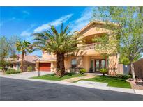 Stunning two-story home boasting a spacious three-car garage and a lush, landscaped front yard with mature palm trees at 10798 Tapestry Winds St, Las Vegas, NV 89141