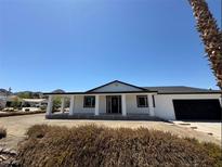 Charming single-story home with a covered porch, black trim, and an attached garage at 1227 San Gabriel Ave, Henderson, NV 89002