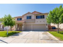 Two-story home with a well-maintained lawn, large driveway, and a three-car garage at 1371 Cumulus Ct, Henderson, NV 89014