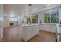 Bright kitchen features an island, white cabinets, wood floors, and large windows with natural light at 1371 Cumulus Ct, Henderson, NV 89014