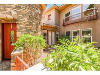 Inviting stone facade entrance with a red door and lush landscaping adds curb appeal to the property at 1737 Cypress Manor Dr, Henderson, NV 89012
