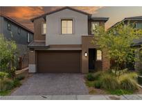 Charming two-story home with a well-manicured front yard and a two-car garage at dusk at 175 Strada Fontana, Henderson, NV 89011