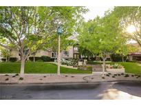 Inviting home exterior with manicured lawn, mature trees, and flowering plants at 1809 White Hawk Ct, Las Vegas, NV 89134