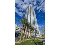 Modern high-rise condo building with stunning architecture and palm trees against a blue sky at 200 W Sahara Ave # 3510, Las Vegas, NV 89102