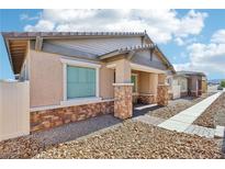 Charming single-story home featuring stone accents, a covered porch, and low maintenance landscaping at 209 Bellini Peak Ave, Henderson, NV 89011