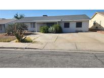 Modest single-story home featuring desert landscaping, a wide driveway, and window bars for added security at 255 Winona Dr, Henderson, NV 89015