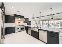 Modern kitchen featuring a large island with stainless steel appliances and dark cabinetry at 3892 Pasilla Ave, Las Vegas, NV 89118