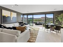Bright living room featuring modern furnishings, artwork, and expansive sliding doors to a patio with mountain views at 40 Heron Harbour Dr, Henderson, NV 89011