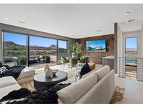 Open-concept living room with modern furniture, a dining area, and a large sliding glass door with mountain views at 40 Heron Harbour Dr, Henderson, NV 89011