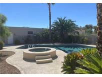 Inviting backyard pool and spa featuring mature landscaping and serene desert views at 6315 Eldora Ave, Las Vegas, NV 89146