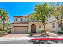 Two-story home with a well-manicured lawn, brick driveway, and mature landscaping, located in a quiet neighborhood at 708 Point Bluff St, Henderson, NV 89002