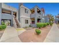 Multi-level condo building with well-maintained landscaping and a walkway to the entrance at 8600 W Charleston Blvd # 1128, Las Vegas, NV 89117