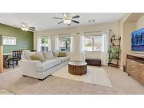 Bright living room featuring a neutral color palette, plush sofa, and stylish round wood coffee table at 1101 Elation Ln # 2, Henderson, NV 89002