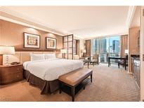 Bright bedroom with a comfortable king bed, seating area, and floor to ceiling windows at 145 E Harmon Ave # 919, Las Vegas, NV 89109