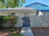 Charming single-story home with a blue-tiled roof, gated entrance, and well-maintained landscaping at 2116 Bavington Dr # C, Las Vegas, NV 89108